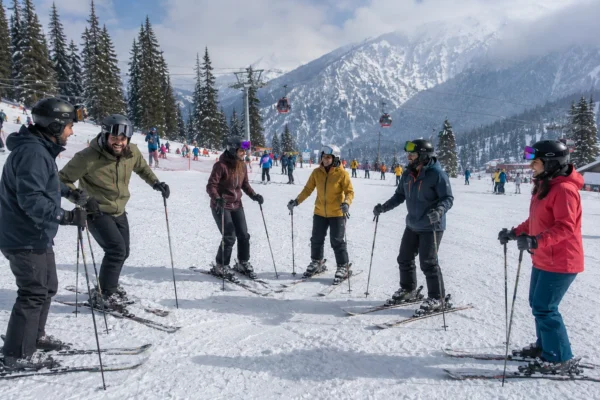 A group of adult beginners smiling during their first ski lesson on nursery slopes