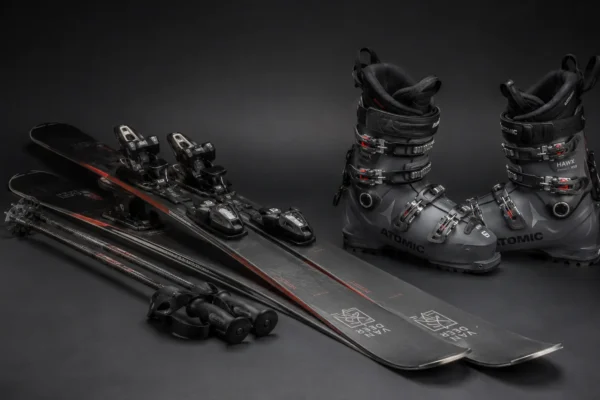 Essential skiing equipment including skis, boots, bindings, and poles for beginners