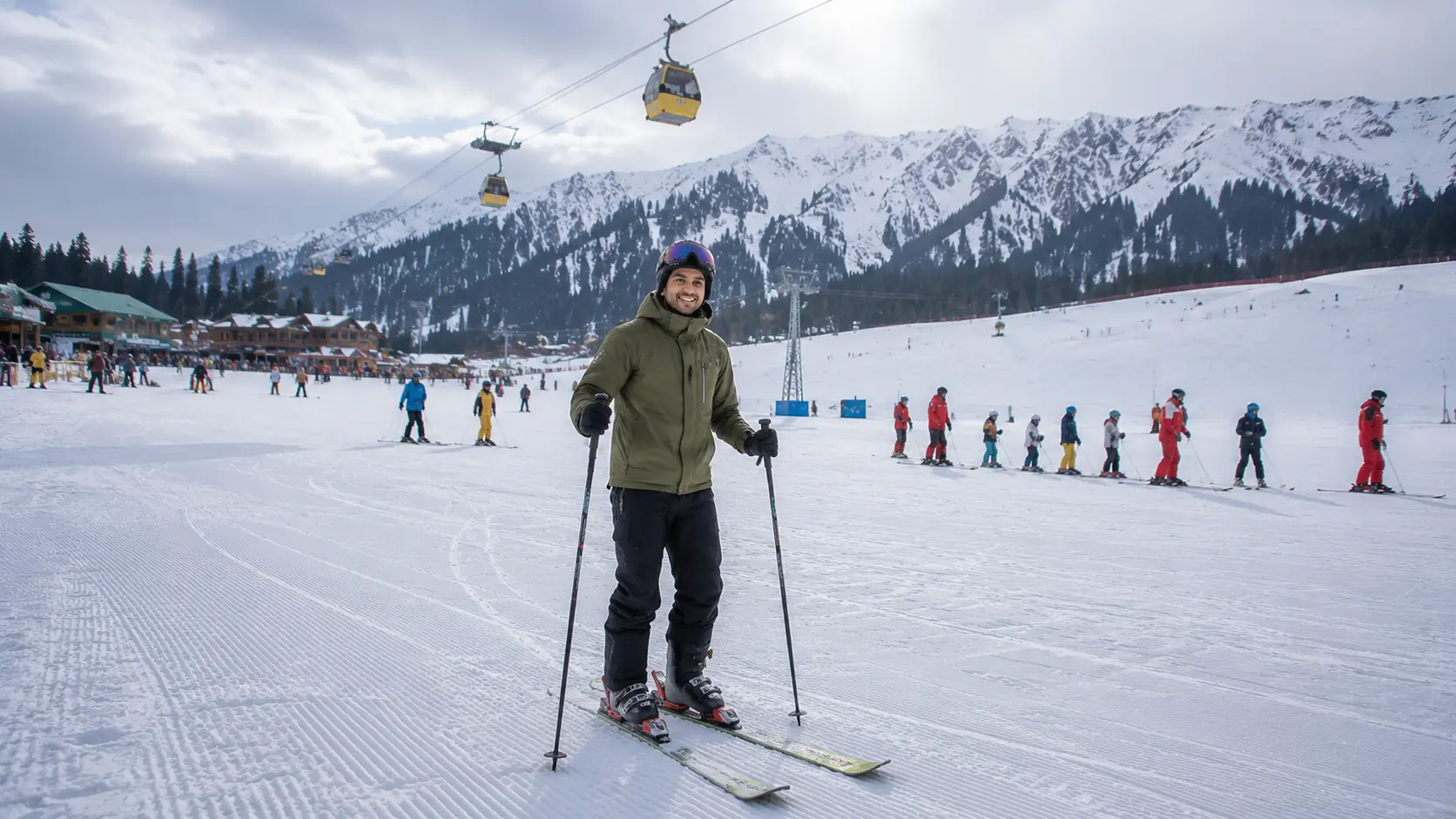 A beginner skier standing on a gentle ski slope in Gulmarg Kashmir during training