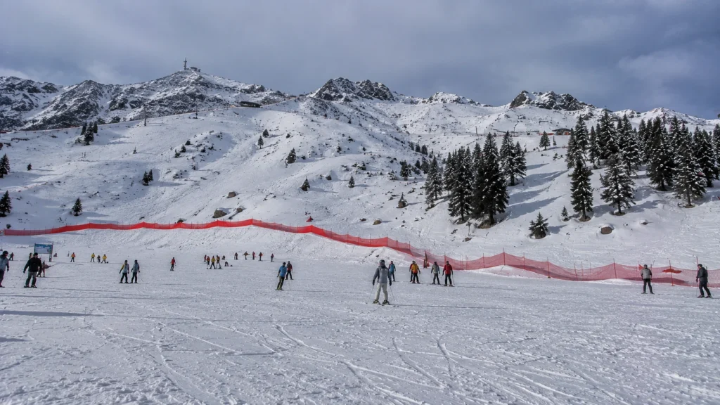 Ski resort safety nets and orange warning markers bordering beginner slopes