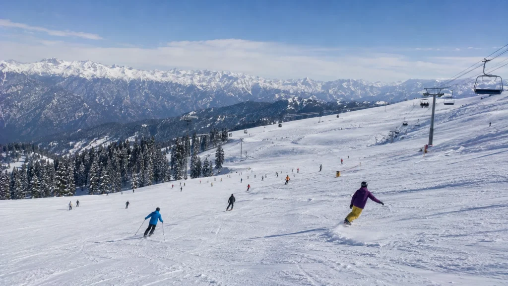 Skiers and snowboarders sharing a wide slope in Gulmarg Kashmir