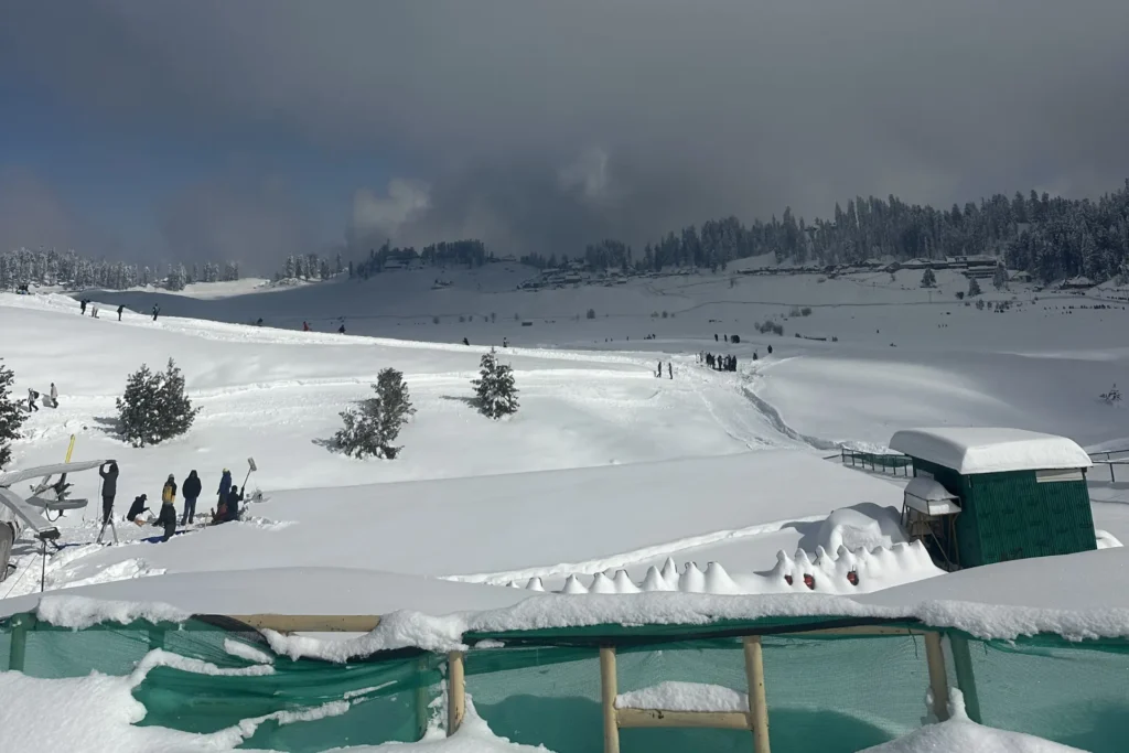Wide view of skiers on snow-covered Himalayan slopes in Gulmarg