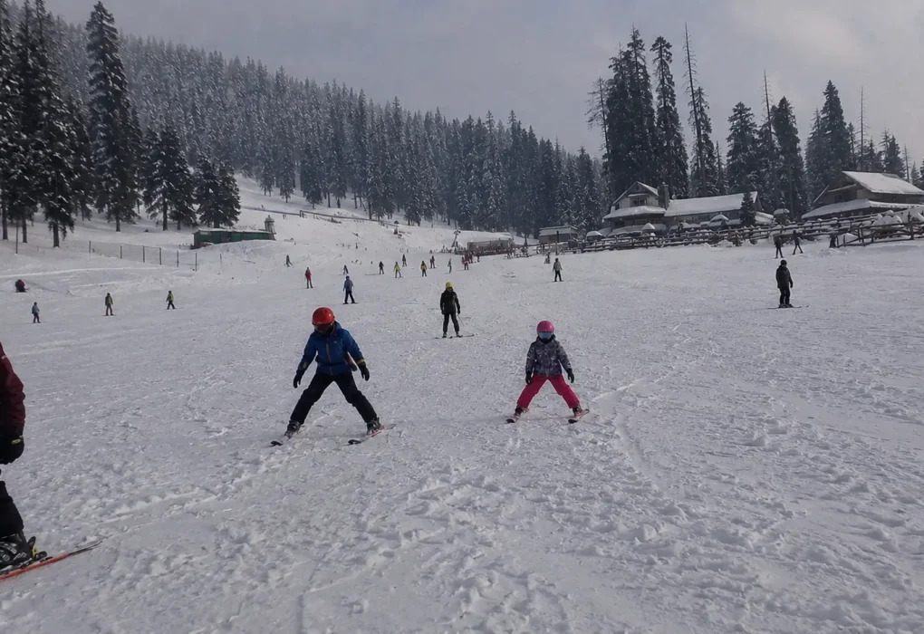 Ski students practicing basic snowplough stance drills on the nursery slopes in Gulmarg