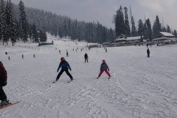 Ski students practicing basic snowplough stance drills on the nursery slopes in Gulmarg